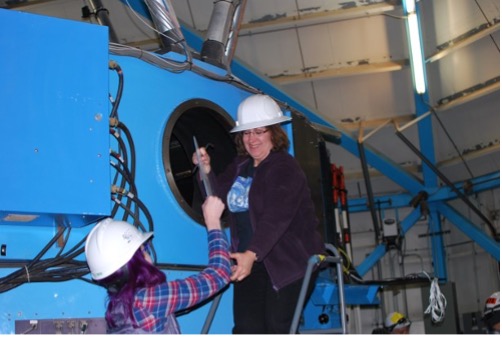 Marsha Wolf removes the cover of the bent Cassegraintelescope port onto which the Port Adapter will be installed on 21October 2019.